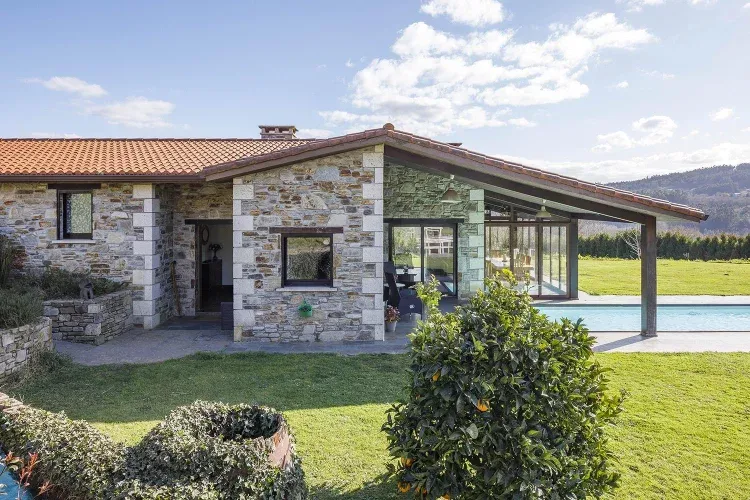 Imagen de Entrada principal de la casa de construcción reciente utilizando piedra del país y madera