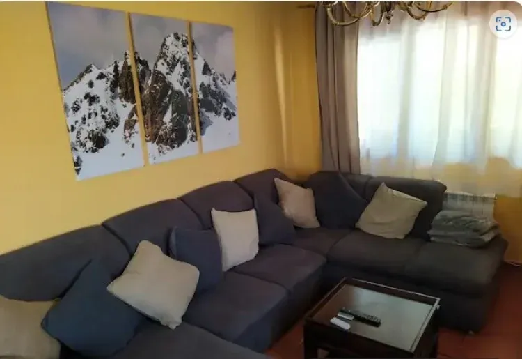 Imagen de Salón, con amplio Sofá, estufa y TV pantalla plana con conexión a internet por fibra óptica y wifi
