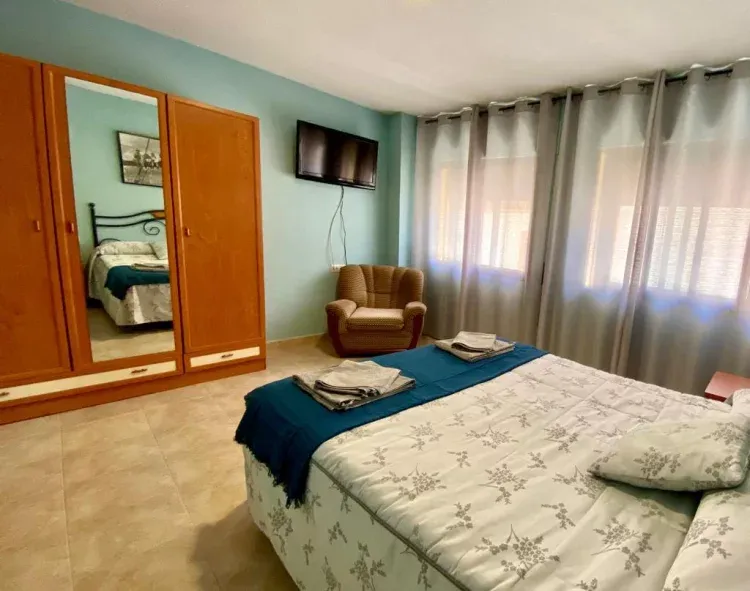 Imagen de dormitorio principal con aire acondicionado y calefaccion individual , televisor opción de cuna y cama supletoria .