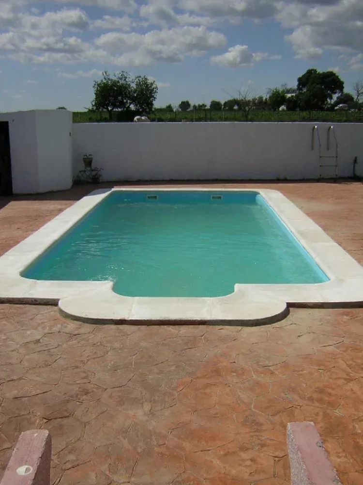 Imagen de piscina con cesped y sombrillas