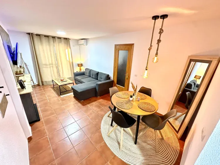 Imagen de Salón comedor  con aire acondicionado y chimenea eléctrica, acompañado por sofá cama dos plazas y Smart TV para ver tus películas y series favoritas. 
