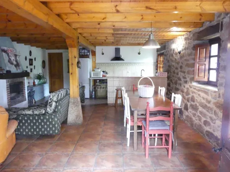 Imagen de Sala de estar con chimenea, mesa de comedor, sofás, cocina, barra americana