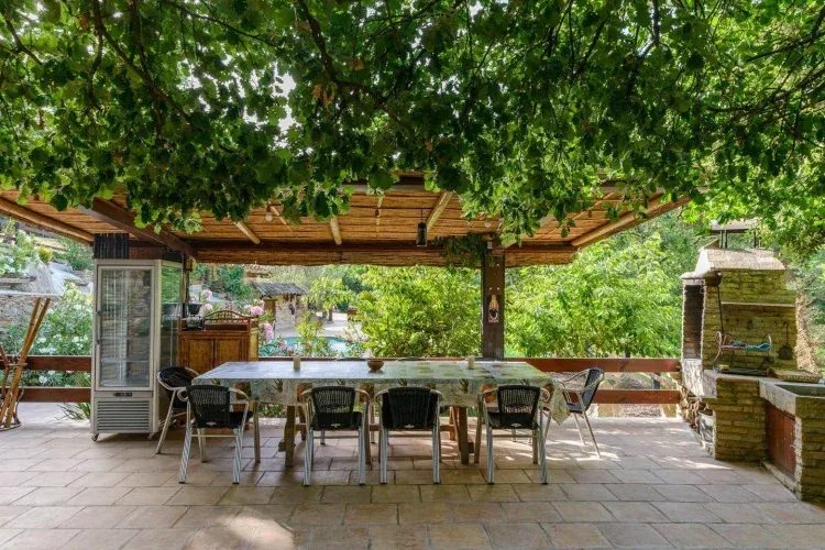 Imagen de Porche Piscina con barbacoa y nevera.