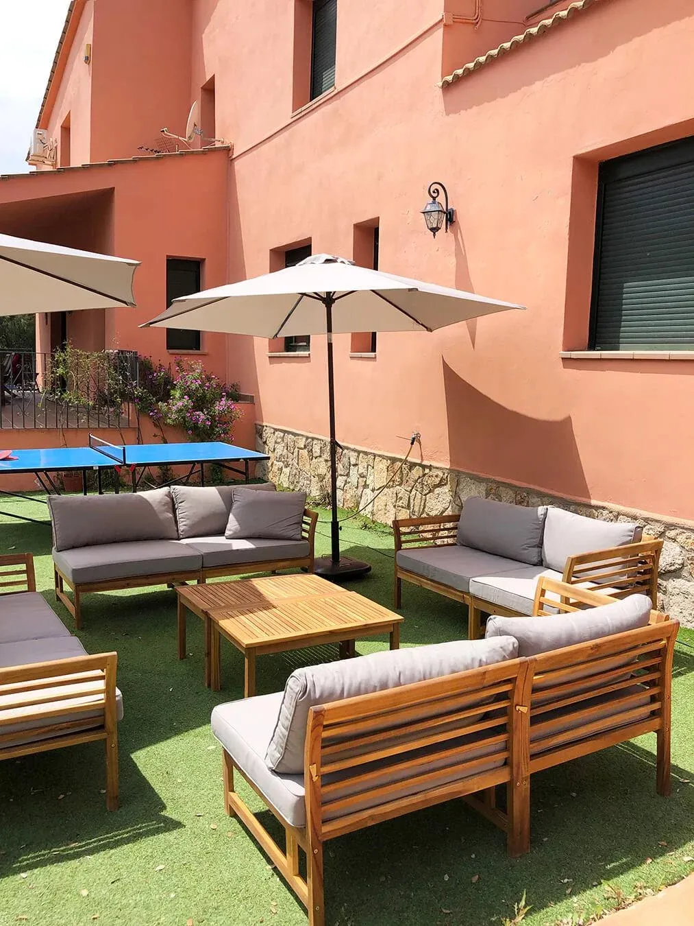 Imagen de Zona de relax con 4 sofás de exterior y parasoles. Mesa de Pingpong.