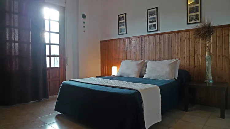 Imagen de habitacion con cama de matrimonio y vistas a la peña.