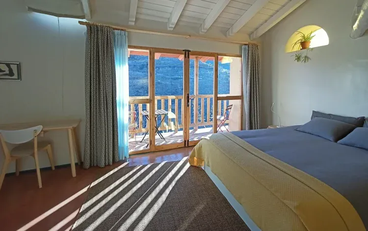 Imagen de Dormitorio amplio y agradable, con cama doble grande, estufa de pellets para los dias más frios, dos butacas, perchero, cuarto de baño completo, escritorio, y un balcón con vistas hermosas. Esta habitación es la parte de la vivienda que no es cueva.