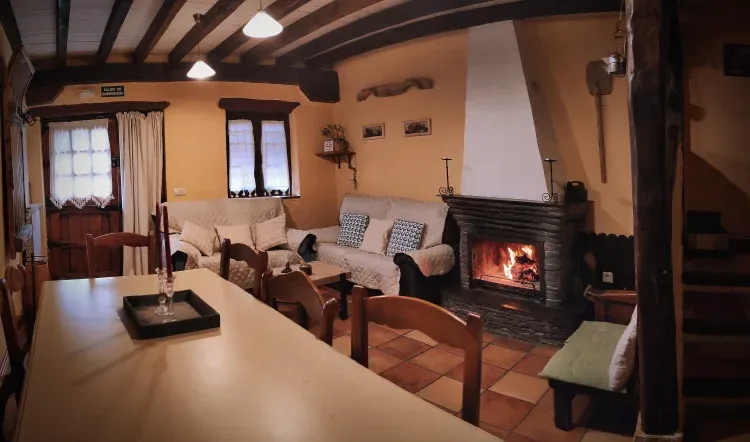 Imagen de El coqueto salón con chimenea de La Melera de Arriba es perfecto en las tardes de otoño e invierno