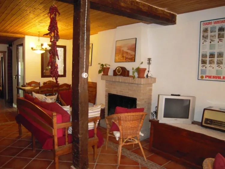 Imagen de Amplio salón con chimenea. Mesa de comedor para 6 comensales y otra mesa camilla para 4 personas. Tenemos silla para bebes.
