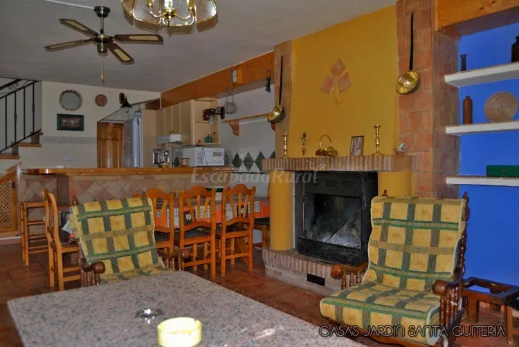 Imagen de Salón con dos sofás, dos butacas y chimenea de leña