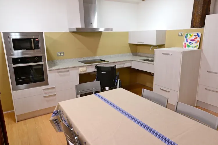 Imagen de gran cocina comedor con todas las comodidades y accesible a todas las personas. Conectada por puertas correderas a una sala de estar para unir y separar ambientes