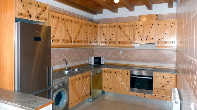 Imagen de Cocina totalmente amueblada con electrodomésticos y menaje para cocinar.