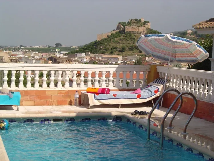Imagen de Piscina climatizada con paneles solares y vistas sobre el castillo y la montaña.
