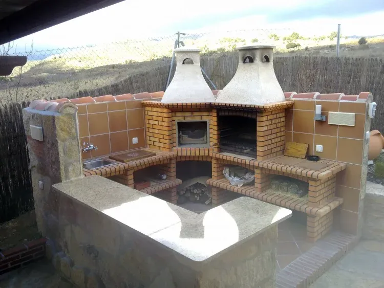 Imagen de Impresionante barbacoa exterior con horno de leña, fregadero y barra.