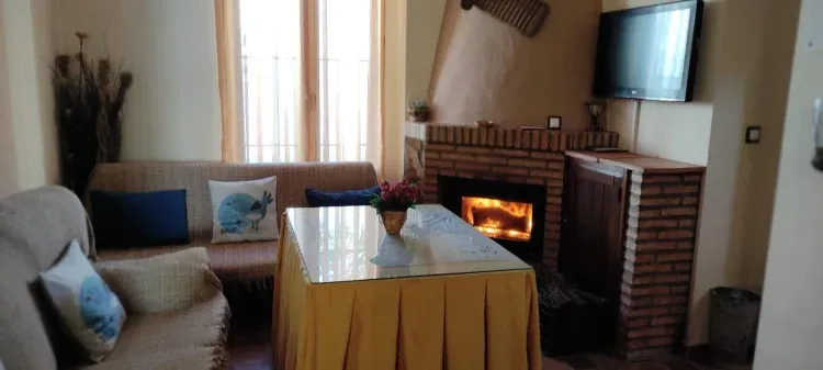 Imagen de Salón con chimenea encendida casa arco