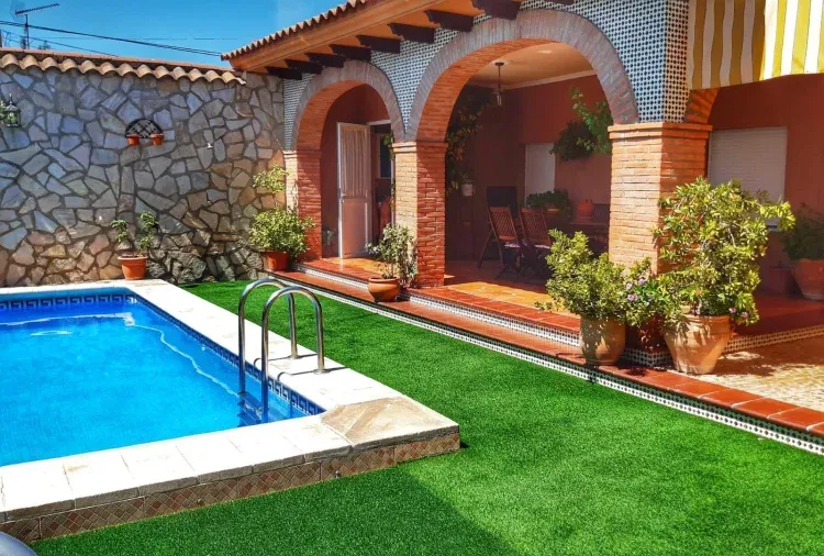 Imagen de Piscina rodeada de cesped artificial
