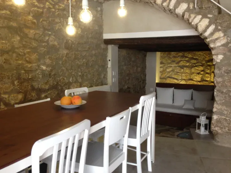 Imagen de Salón-Comedor. Tras el sofá se encuentra el inicio de la antigua muralla medieval del siglo XII.