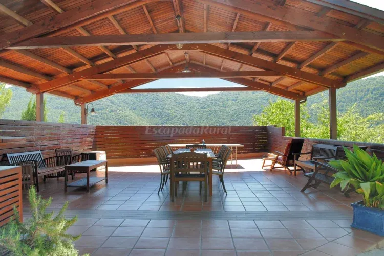 Imagen de Gran porche exterior con barbacoa ideal para comidas al aire libre.