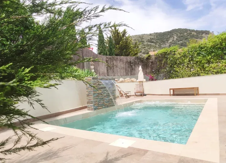Imagen de piscina privada de agua salina con zona de cascada y jacuzzi