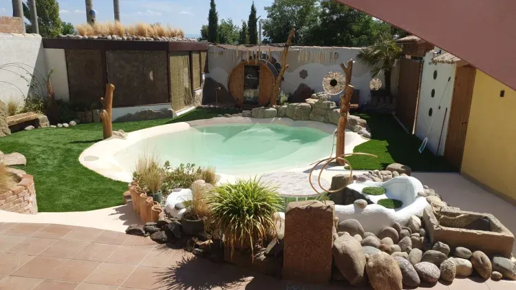 Imagen de piscina-platja amb cascada, zona relax i sauna