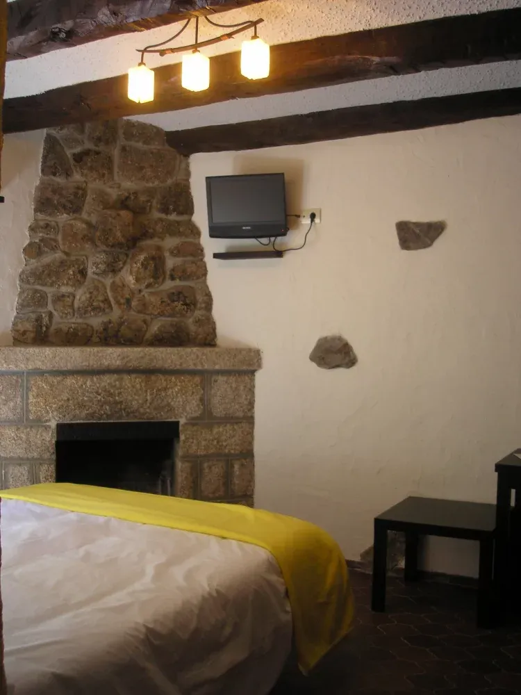 Imagen de Chimenea decorativa de piedra natural en hab. de cama de matrimonio