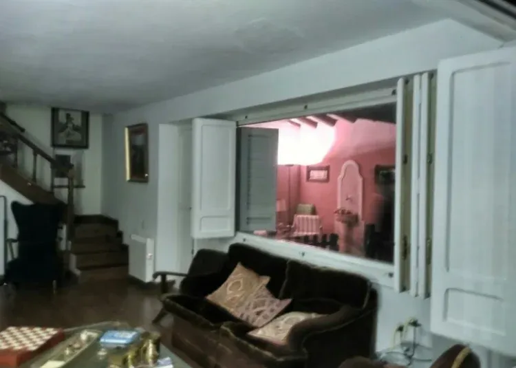 Imagen de Sala y terraza iluminada de noche